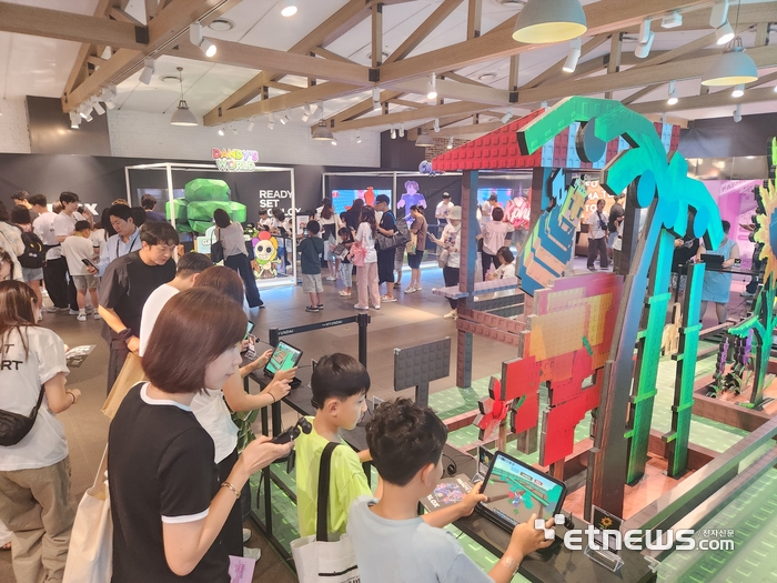 판교 현대백화점 지하 1층에 마련된 로블록스 팝업 스토어에서 방문객이 게임을 즐기고 있다.