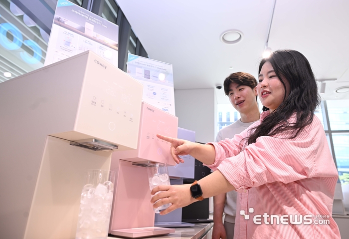 서울 구로구 코웨이갤러리 구로지타워 직영점에서 고객이 국내 얼음정수기 중 가장 작은 크기를 지닌 신제품 아이콘 얼음정수기 미니, 스탠다드 제품을 살펴보고 있다.  박지호기자 jihopress@etnews.com