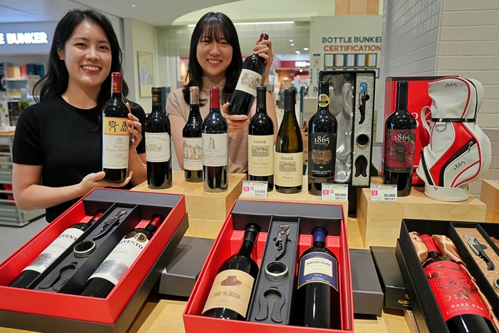 모델들이 롯데마트 추석 사전 예약 행사에서 판매하는 주류 선물 세트를 홍보하고 있다.