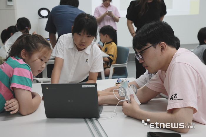 42경산 교육생이 경산시립농촌보육정보센터 초등학생과 함께 코딩블럭으로 자율주행 자동차를 제작하고 있다.