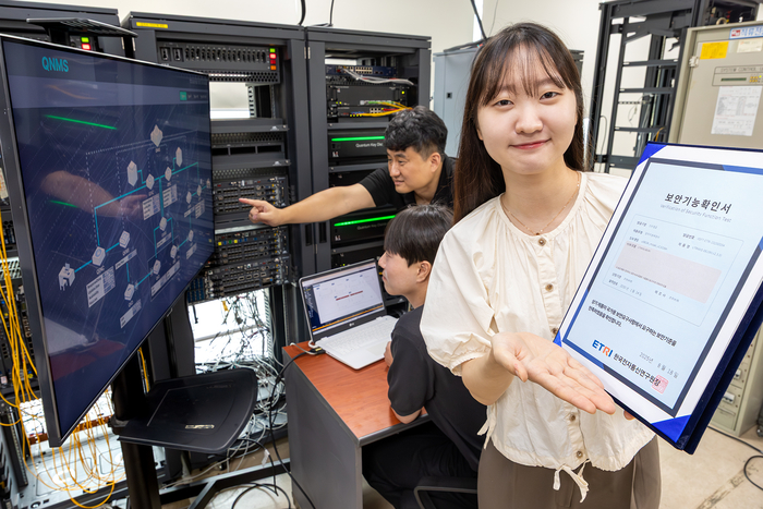 KT와 코위버 직원이 양자키분배 기술 적용 장비를 점검하며 보안 인증서를 소개하는 모습