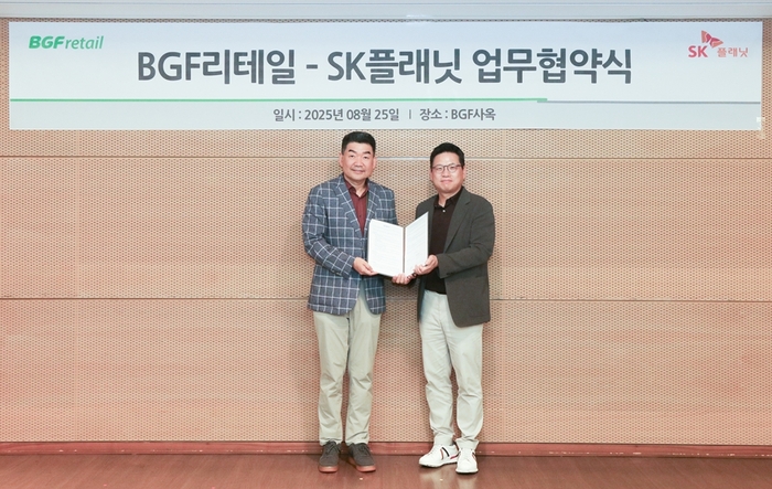 오정후 BGF리테일 전략혁신부문장(왼쪽)과 김교수 SK플래닛 사업본부장이 MOU 기념 사진을 촬영하고 있다.