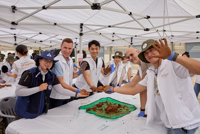 마티아스 바이틀 메르세데스-벤츠 사회공헌위원회 의장(왼쪽 두번째)이 벤츠코리아 임직원들이 수질 정화에 도움을 주는 미생물 흙공을 제작하고 있다.
