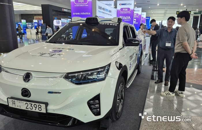 '에스더블유엠'가 운영 중인 로보택시 솔루션에 대해 관람객들이 설명을 듣고 있다.