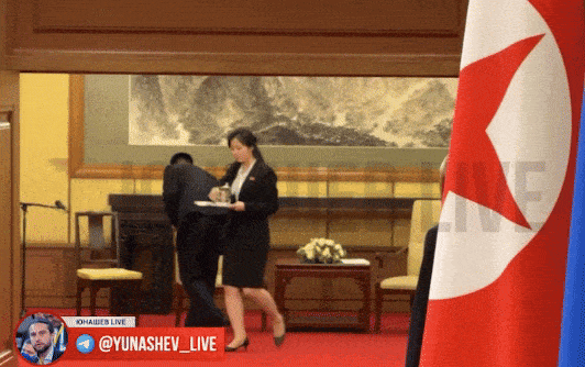 북한 수행원이 김정은 국무위원장이 닿은 곳을 닦고 유리잔을 치우고 있다. 사진=텔레그램(@Yunashev_Live) 캡처