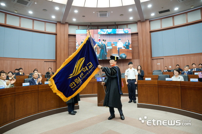 최양희 한림대 제12대 총장이 10일 열린 취임식에서 교기를 흔들고 있다.