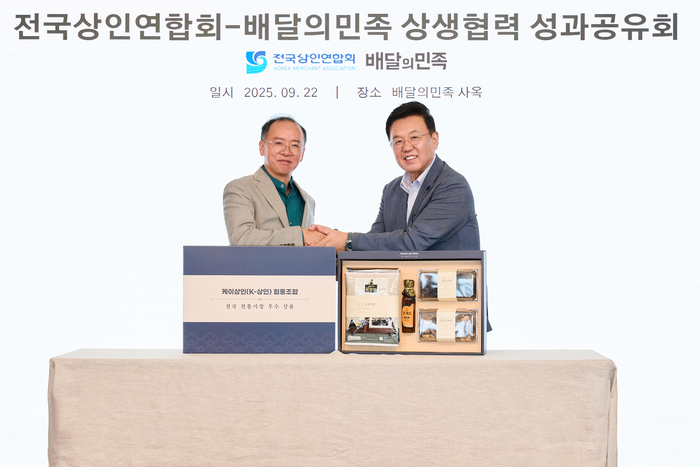 윤석준 우아한형제들 총괄사장(오른쪽)과 이충환 전국상인연합회 회장이 지난 22일 서울 송파구 롯데월드타워 사옥(더큰집)에서 '상생협력 성과공유회'를 기념해 사진 촬영을 하고 있다.