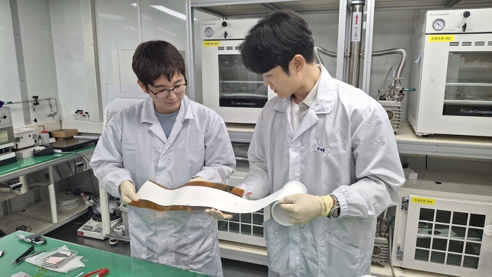 ETRI 연구진이 롤 형태로 제조한 대면적 고체전해질막을 점검하고 있다.