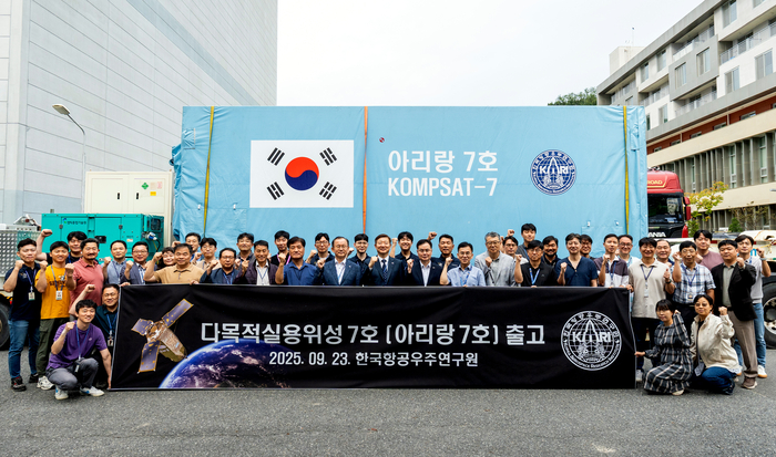 우주항공청과 한국항공우주연구원 관계자들이 23일 발사준비를 위해 남미 기아나우주센터로 떠나는 아리랑 7호 앞에서 기념촬영을 했다. (우주청 제공)