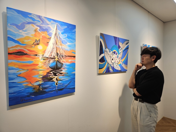 현대제철 직원이 올모용인 사업장에 걸린 소속 발달장애인 작가들의 작품을 감상하고 있다. 현대제철