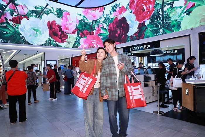 중국인 고객이 신세계면세점 명동점 10층 아이코닉존 미디어파사드를 감상하고 있다.