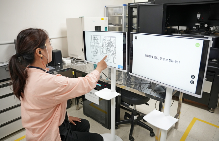 연구진이 웨어러블 기기를 착용하고 AI 기반 발화 및 뇌파 분석 기술을 시연하고 있다.