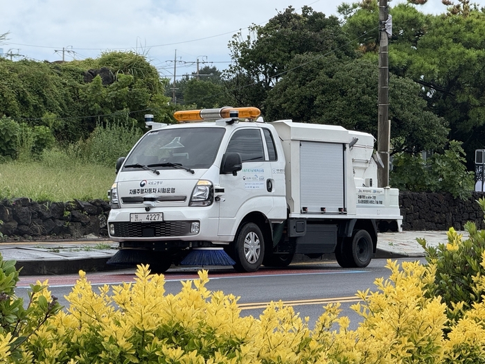 시범운행 차량이 제주 시내를 주행하며 도로를 청소하고 있는 모습.