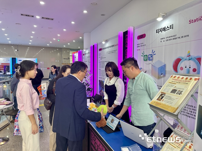 관람객이 춘천 스테이션C 창업엑스포 부스에서 설명을 듣고 있다.