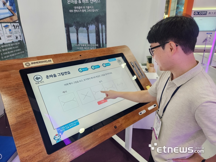 이머시브랩 관계자가 시니어 맞춤형 정신건강관리 AI 아트 테라피 솔루션 '하트캔버스'를 시연하는 모습. (사진=김신영 기자)