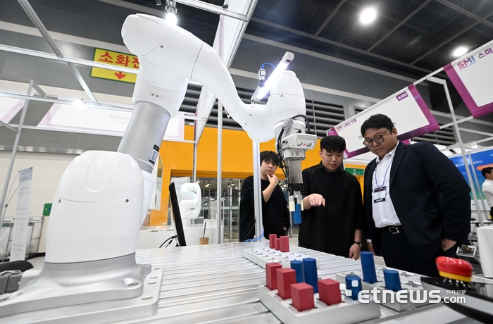 스마트제조혁신협회가 주최한 '2025 제조혁신코리아'가 22일 서울 서초구 aT센터에서 열렸다. 에스넷 부스에서 관람객이 협동로봇 기반 인공지능(AI) 로봇 실습 플랫폼을 살펴보고 있다. 김민수기자 mskim@etnews.com