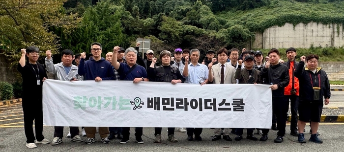 지난 14일 부산광역시 남구 한국도로교통공단 부산남부운전면허시험장에서 열린 '찾아가는 배민라이더스쿨' 참가자들이 기념사진을 촬영하고 있다. 〈자료 우아한청년들〉