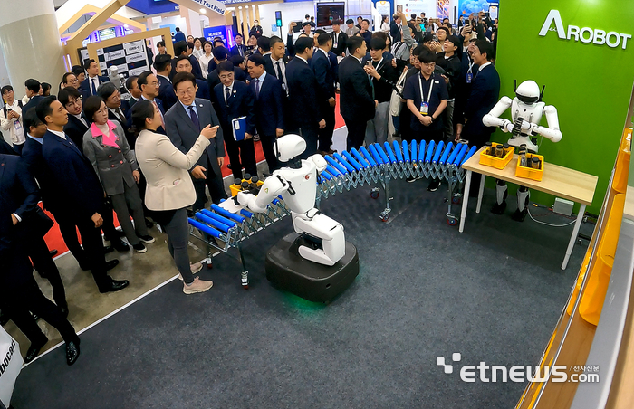 이재명 대통령이 타운홀 미팅을 마치고, FIX 2025 로봇관을 깜짝 방문해 설명을 듣고 있다.