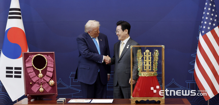 이재명 대통령이 29일 경북 경주박물관에서 도널드 트럼프 미국 대통령에게 '천마총 금관 모형'을 선물한 뒤 악수하고 있다.  연합뉴스