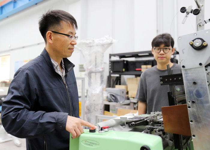 박철훈 한국기계연구원 첨단로봇연구센터 책임연구원이 근육옷감 자동직조기를 작동시키고 있다.