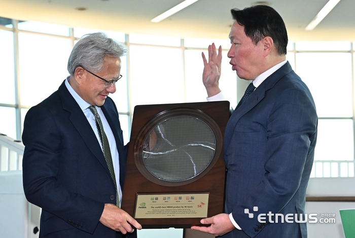젠슨 황 엔비디아 CEO가 31일 경북 경주시 경주예술의전당에서 열린 아시아태평양경제협력체(APEC) CEO 서밋에 참석해 최태원 SK그룹 회장 겸 대한상의 회장으로 부터 SK하이닉스의 HBM4 반도체 웨이퍼를 선물로 받고 있다. 경주=이동근기자 foto@etnews.com