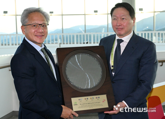 젠슨 황 엔비디아 CEO가 지난달 31일  경주 예술의전당에서 열린 APEC CEO 서밋에 참석해 최태원 대한상의 회장으로부터 SK하이닉스의 HBM4 반도체 웨이퍼를 선물로 받고 있다. 경주=이동근기자 foto@etnews.com