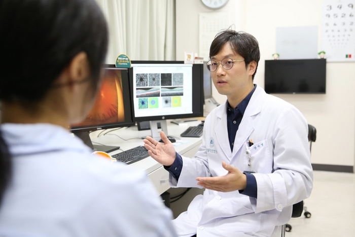 양지명 서울아산병원 안과 교수가 환자에게 망막 혈관 검사 결과를 설명하고 있다.(사진=서울아산병원)