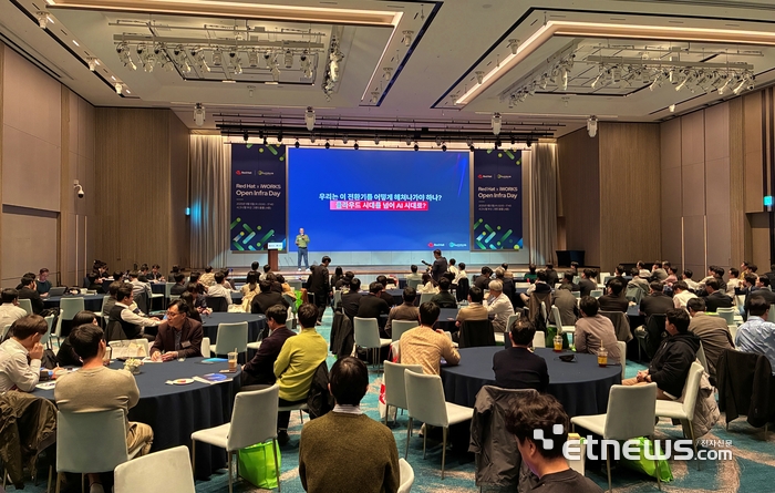 아이웍스가 5일 부산 시그니엘호텔에서 개최한 '오픈 인프라 데이 2025' 키노트 발표자로 나선 한국레드햇 천상진 상무의 발표를 참석자들이 경청하고 있다.