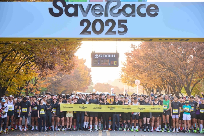 카카오뱅크와 유니세프가 함께 주최한 친환경 기부 마라톤 'Save Race 2025'가 지난 9일 서울 상암 월드컵공원에서 열렸다. 참가자 5천 명이 마라톤 출발선에서 기념 촬영을 하고 있다.