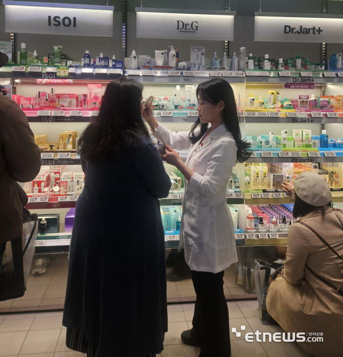 명동에 위치한 올리브영에서 한 외국인이 닥터지 AI 피부 진단 서비스를 받고 있다.