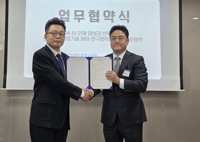 이상훈 시스원 대표(오른쪽)와 백윤주 부산대  SW융합교육원장이 산학협력 MOU를 교환하고 악수를 나누고 있다.