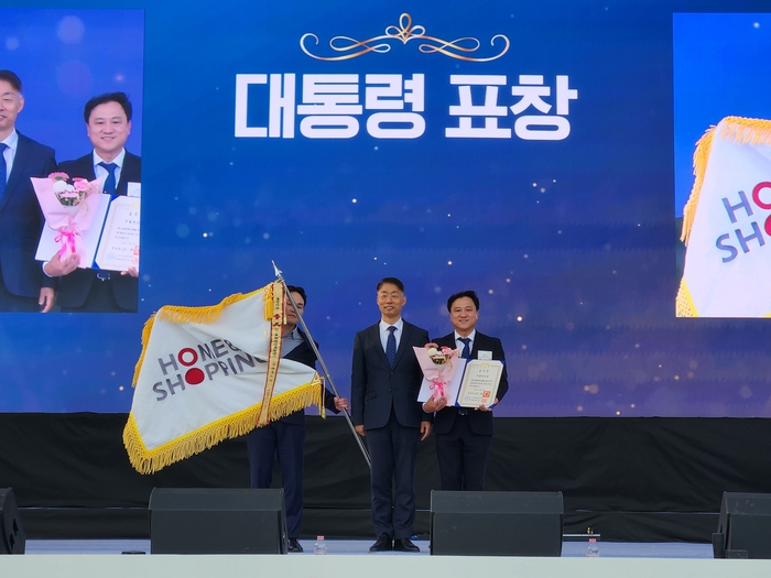 홈앤쇼핑 구기대 부장과 홈앤쇼핑 한정훈 과장이 수상을 기념하며 포즈를 취하고 있다.