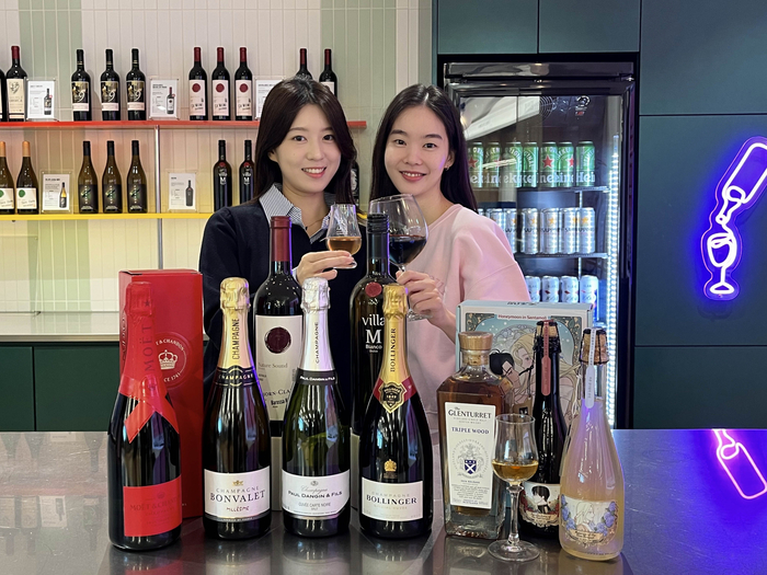 GS25에서 모델이 '2025 와와페' 주류 상품을 선보이고 있다.