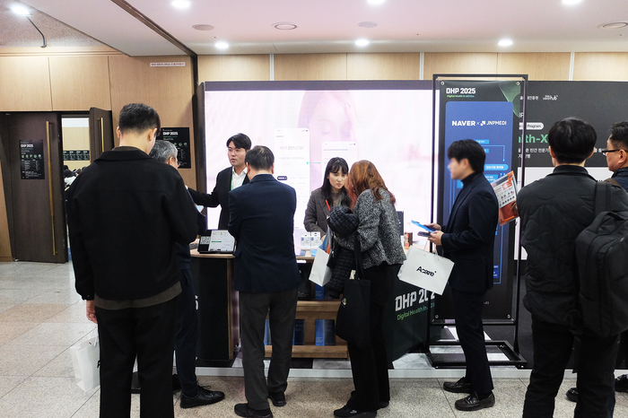제이앤피메디 김진곤 상무(왼쪽)와 이승미 전무가 13일 서울 강남구 한국과학기술회관에서 열린 DHP 2025 제이앤피메디X네이버 부스에서 참관객에게 디지털 헬스케어 서비스에 대해 설명하고 있다.(사진=제이앤피메디)