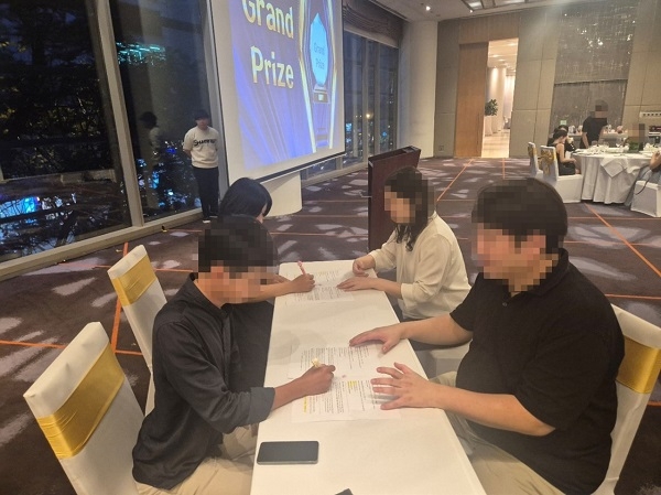 웹툰 공모전 수상자가 웹툰 저작 참여 계약서에 서명하고 있다. 사진=다온크리에이티브