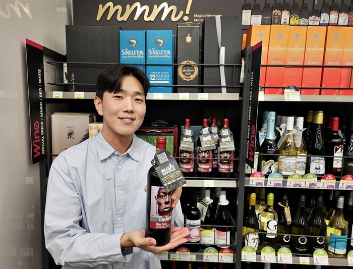 모델이 더 뮤즈 마일스 데이비스 와인을 소개하고 있다.