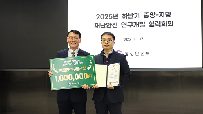 최준호 인텔리빅스 연구소장(오른쪽)이 2025 대한민국 재난안전 연구개발 대상 수여식에서 홍종완 행정안전부 사회재난실장과 함께  기념사진을 촬영하고 있다. (인텔리빅스 제공)