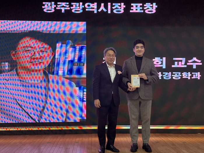 25일 광주테크노파크 12층 대연회장에서 열린 '2025 광주·전남 과학기술인의 밤' 및 '인공지능(AI)빅데이터·기후환경에너지 혁신 포럼'에서 정석희 전남대 교수가 광주시장상을 수상하고 있다. 정 교수 대리 수상 모습.