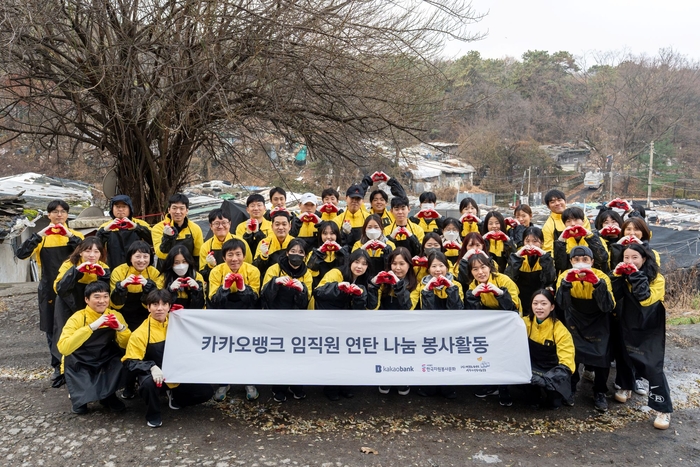 카카오뱅크 임직원들이 지난 25일 서울 강남구 구룡마을에서 '사랑의 연탄 나눔' 봉사활동을 마친 뒤 기념촬영을 하고 있다.