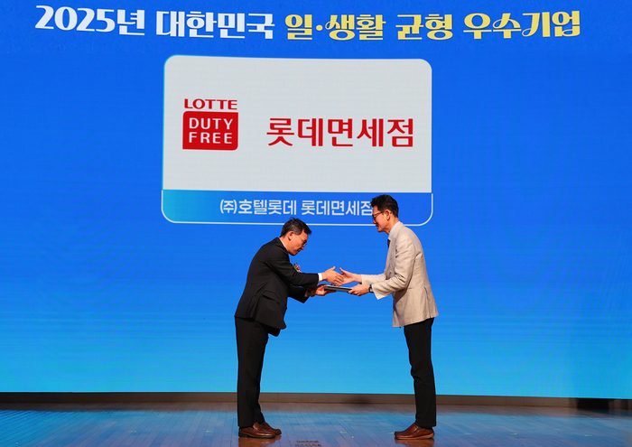 고용노동부가 주관하는 '2025 일·생활 균형 우수기업' 시상식에서 박상호 롯데면세점 경영지원부문장(사진 우측)이 이명로 중소기업중앙회 상무이사로부터 상을 전달받는 모습.