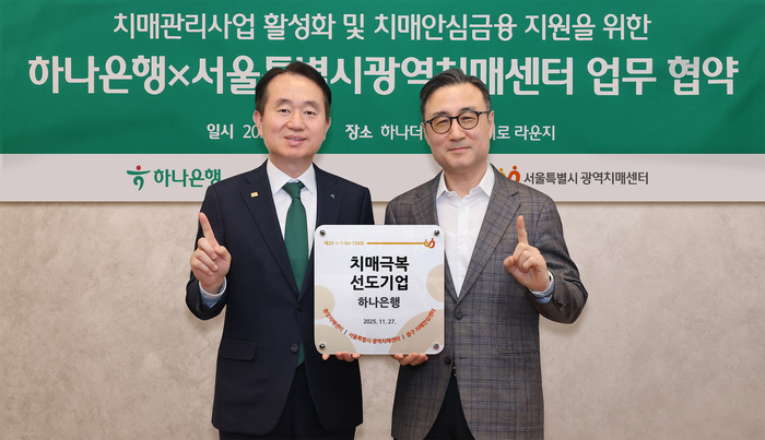 김영훈 하나은행 자산관리그룹 부행장(사진 왼쪽)과 이동영 서울특별시광역치매센터장(사진 오른쪽)이 '치매극복선도기업' 현판을 전달하고 기념촬영을 하고 있다. 사진제공=하나은행