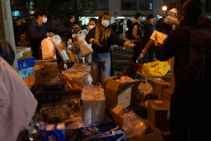 홍콩 아파트 화재 현장 인근에서 자원봉사자들이 주민들에게 생필품을 나눠주고 있다.  사진=AP 연합뉴스