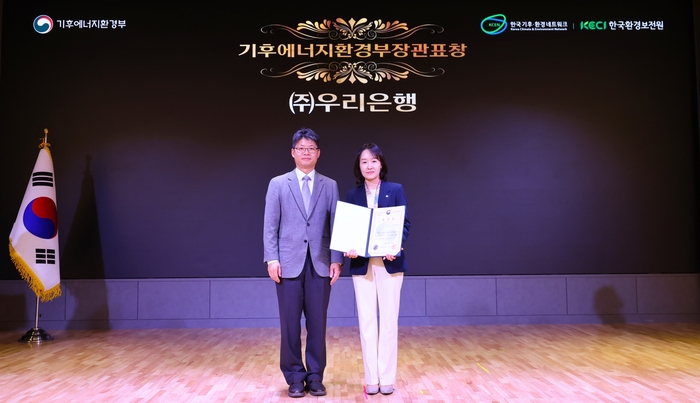 우리은행이 지난 2일 '2025 탄소중립 생활 실천 국민대회'에서 기후에너지환경부장관 표창을 수상한 뒤, 이현주 우리은행 ESG상생금융부장(오른쪽)과 오일영 기후에너지환경부 기후에너지정책실장(왼쪽)이 함께 기념촬영을 하고 있다. 사진제공=우리은행