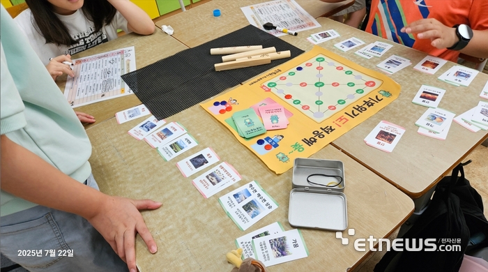 용인시 기후변화체험교육센터가 자체 개발한 교구 '기후위기도 적응해 윷'을 어린이들이 즐기고 있다.