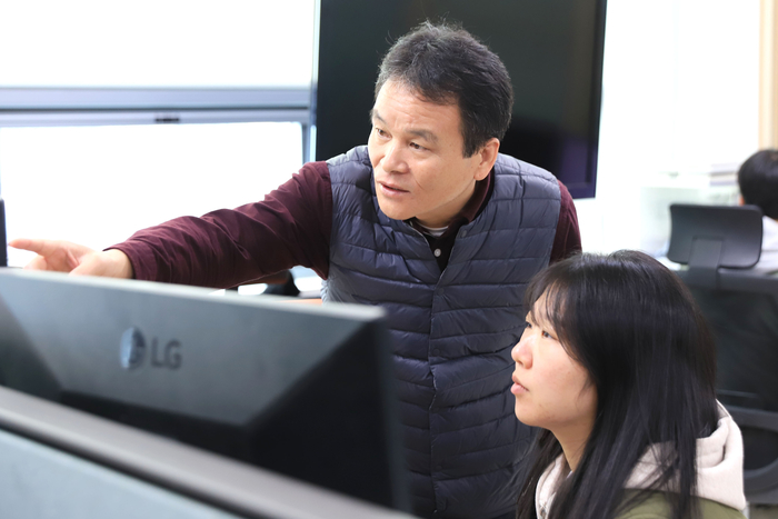 기업협력프로젝트에 참여한 교육생 송아랑 씨(오른쪽)가 김호철 이모션 대표와 함께 플랫폼 개발 화면을 보며 실무 작업을 진행하고 있는 모습.