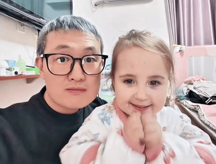 중국 장쑤성에 거주하는 양씨와 딸 궈장. 격세유전으로 인해 딸만 금발에 푸른눈을 가진 모습. 사진=웨이보 캡처