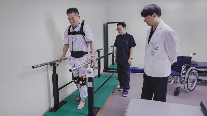 ETRI가 개발한 초경량 탄성슈트를 입고 충북대병원 의료진과 재활훈련을 하는 환자 모습