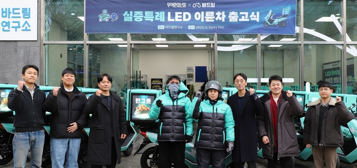 우아한청년들이 지난 10일 서울 강남구 바드림연구소에서 '실증특례 발광다이오드(LED) 이륜차' 출고식을 개최한 가운데 바드림연구소 관계자, 라이더들이 기념사진을 촬영하고 있다. 〈자료 우아한청년들〉