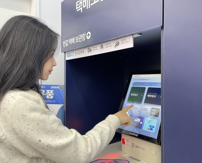 모델이 GS25에서 택배를 접수하고 있다.