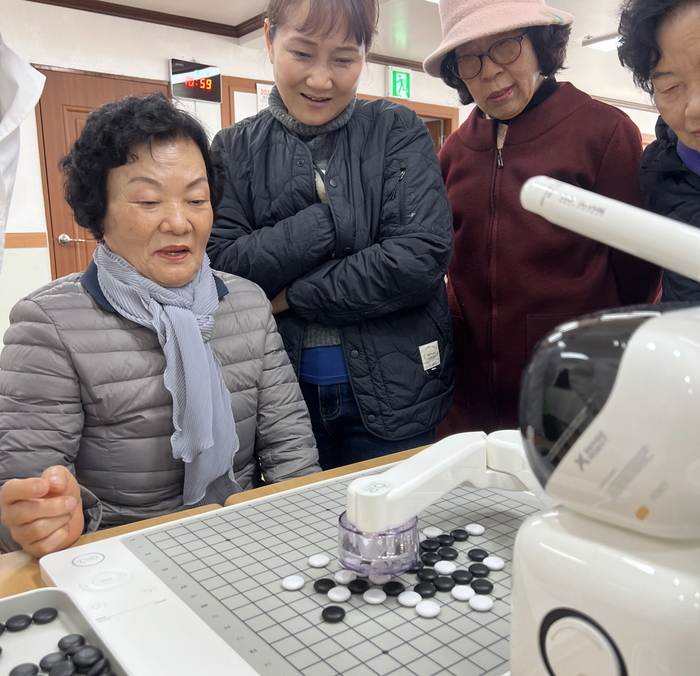 AI로봇과 오목게임을 대결 중인 어르신 모습.